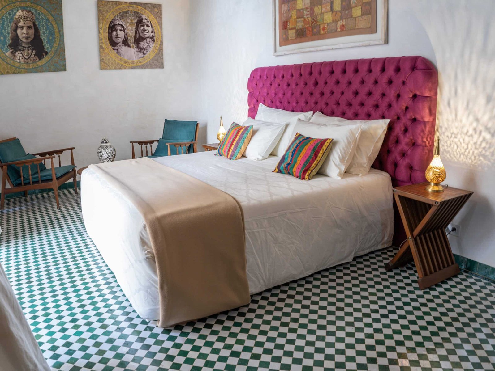 Chambre de riad avec lit king-size, fauteuils et décoration artisanale marocaine.