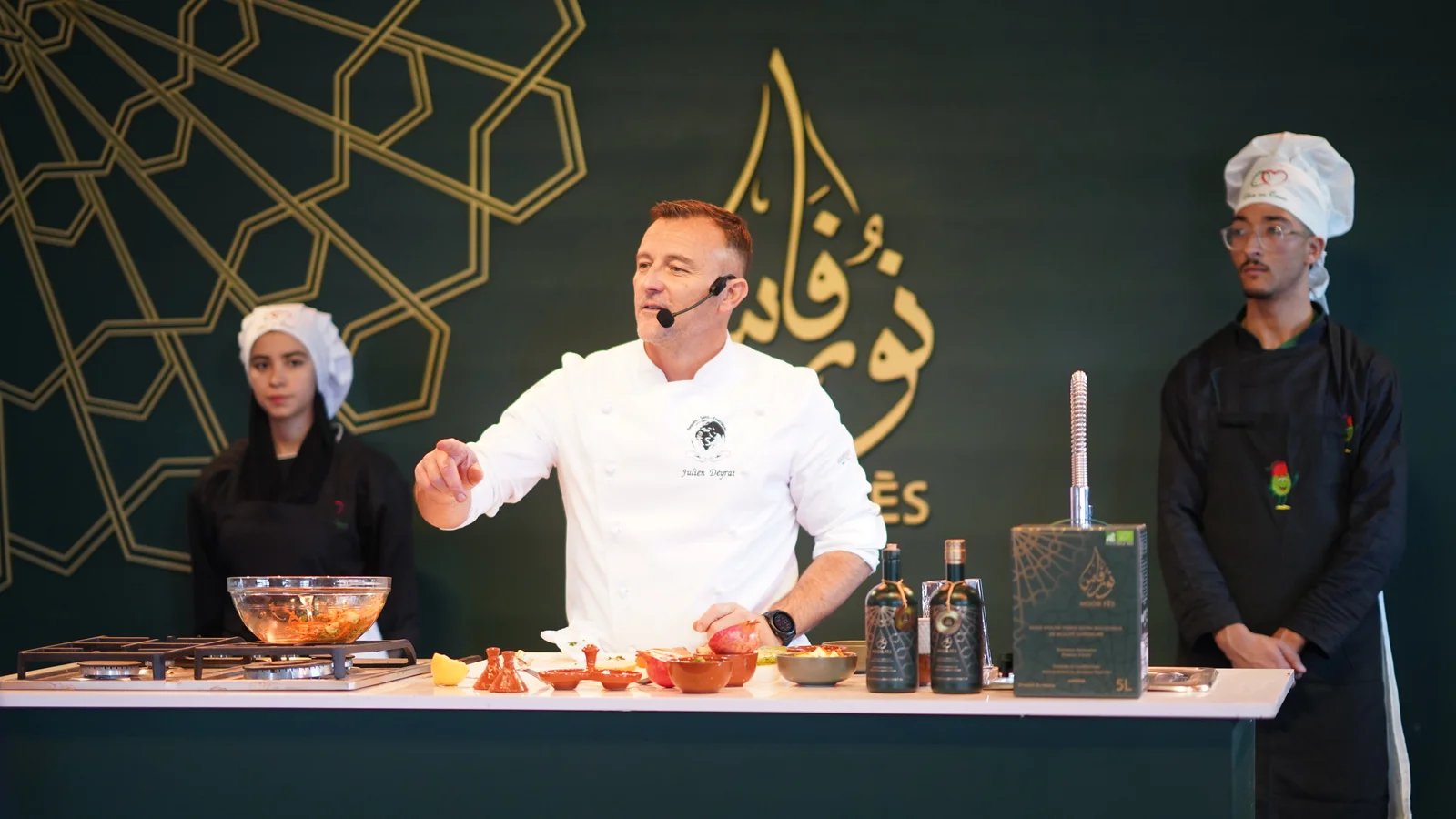 Professional chef demonstrating Moroccan cuisine using premium extra virgin olive oil during a live cooking event.