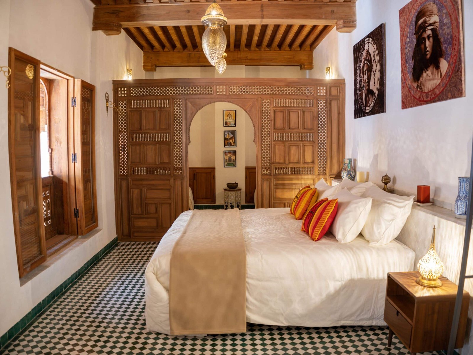 Deluxe suite at Riad Dar Flores in Fes featuring a king-size bed, handcrafted cedar wood ceiling, traditional Moroccan décor, and authentic boutique riad architecture.