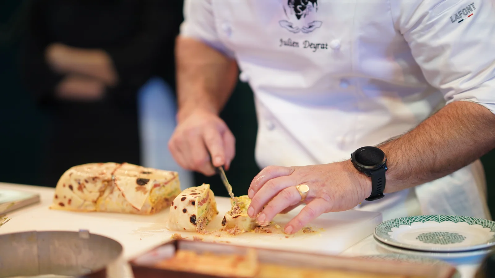 Chef slicing a traditional Moroccan pastilla during a live culinary presentation.