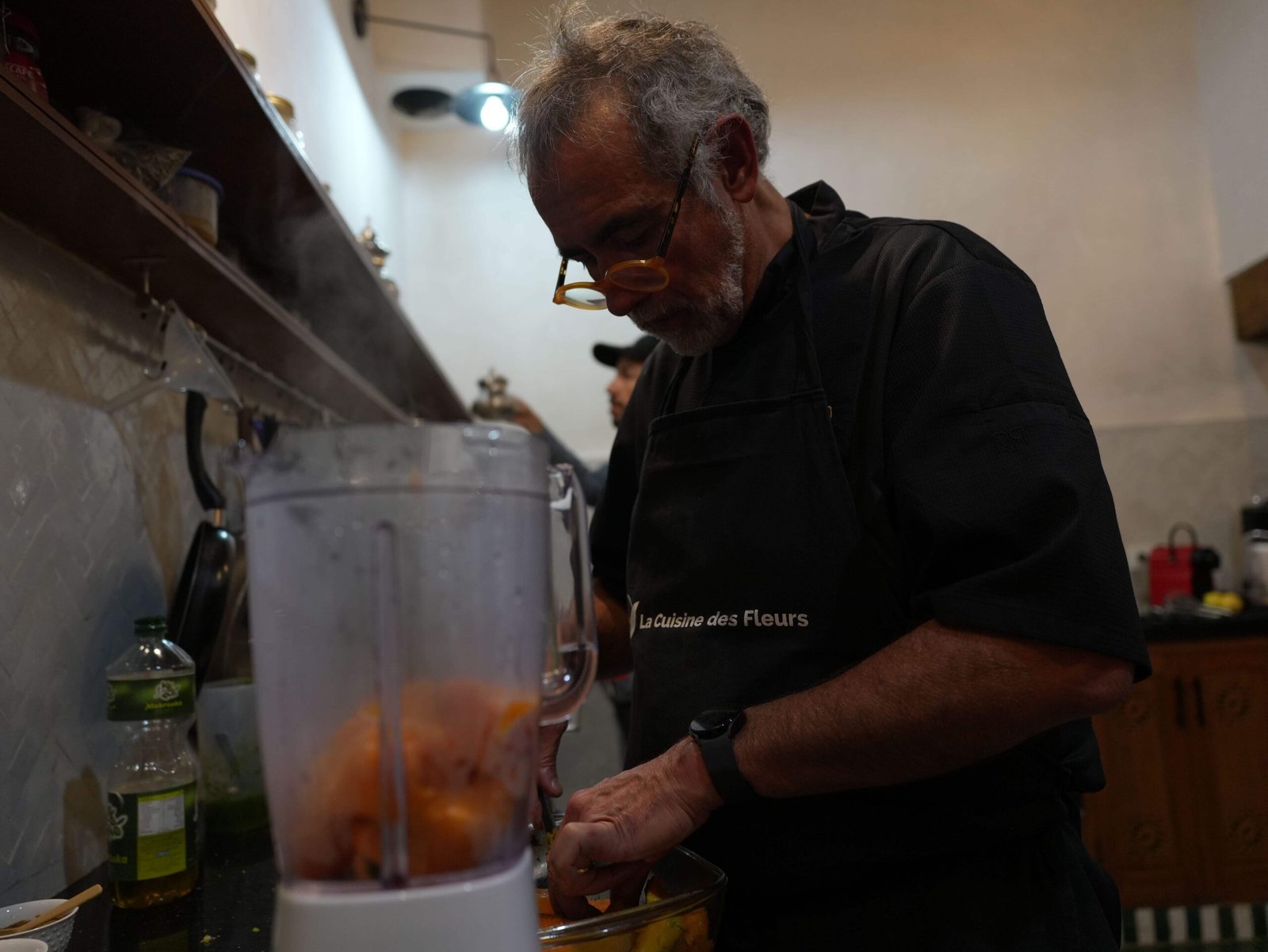 Chef preparing ingredients beside a blender in a Moroccan kitchen