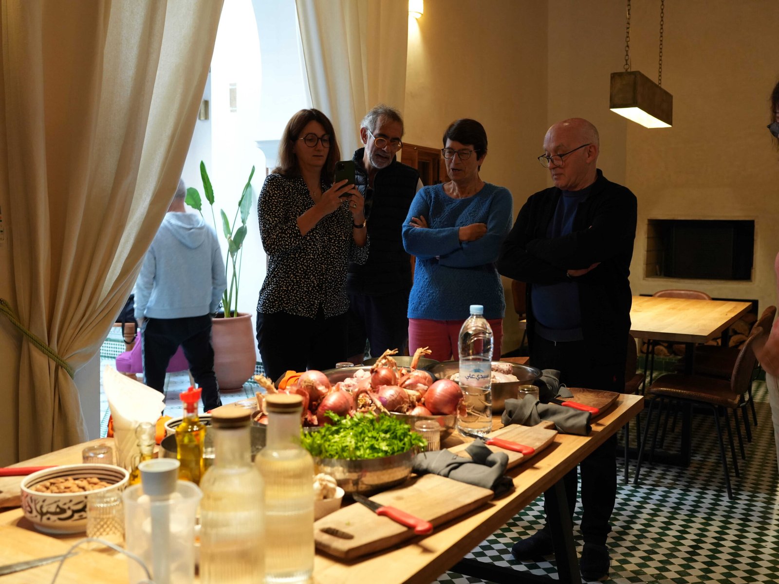 Guests reviewing a recipe beside fresh ingredients during a Moroccan cooking class