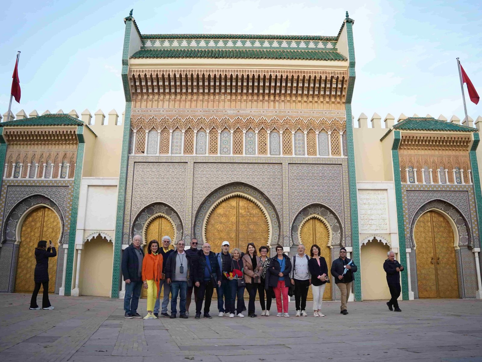 Tour group standing in front of the golden gates of the Royal Palace in Fez, Morocco.
