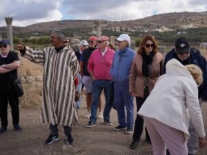 Local guide leading visitors through the Roman ruins of Volubilis in Morocco.